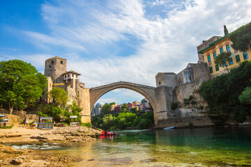 Obraz premium Historic Mostar Bridge Stari Most Over Neretva River on a Sunny Day in Bosnia and Herzegovina