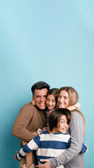 Fototapeta premium Parents and children embracing on a light blue background, smiling and joyful, showing family love, togetherness and affection