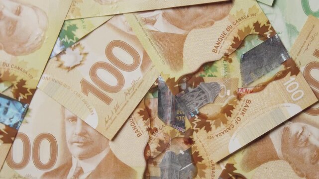 Piles of Canadian banknotes in shades of green and orange create a rich tapestry of texture and design. Enjoy the intricate details of each bill