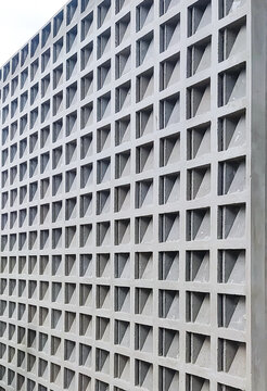 Perforated concrete ventilation wall with repeating geometric openings, providing airflow and natural light while adding texture and pattern to modern residential or building design.
