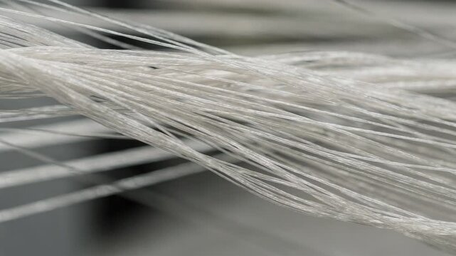 Closeup focus on polyamide microfiber fibers being spun and aligned emphasizing durability and softness in wipe manufacturing.
