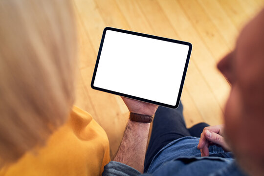 Couple sharing tablet with blank screen at home