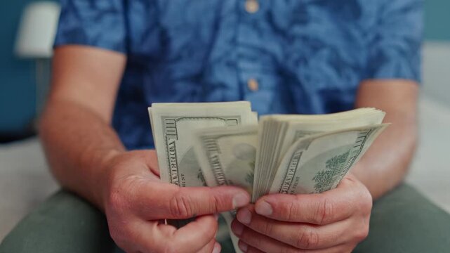 Hands skillfully sort through crisp Canadian dollars in a tranquil indoor space, showcasing the careful act of counting money with precision and ease