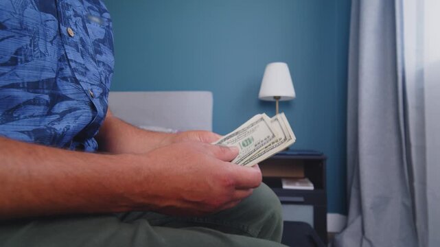 A man's hands skillfully sort and count Canadian currency in a calm, well-lit room. The serene atmosphere enhances the focus on each note