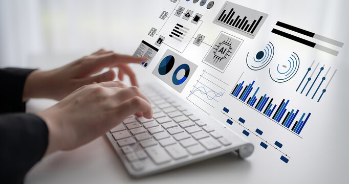 A close-up view of hands typing on a keyboard with an array of digital graphs and charts floating above, representing data analysis and technology in a modern workspace. Gantry