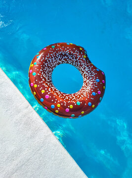 swimming pool ring float in blue water and sky sunlight reflection, holiday and vacation, summer background, top view copy space