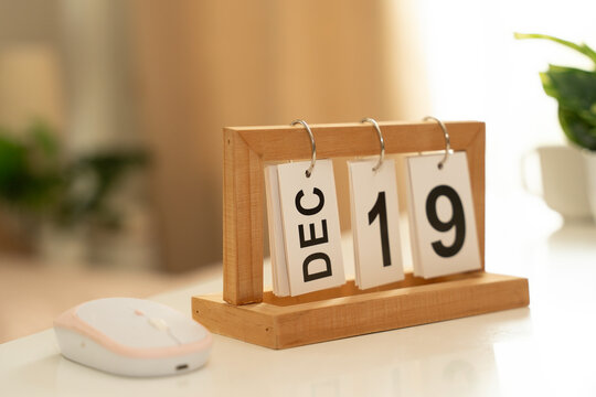 Special occasion and memorable date concept. Wooden desk calendar displaying December 19 in a modern workspace, symbolizing celebration, milestone, event, anniversary, reminder