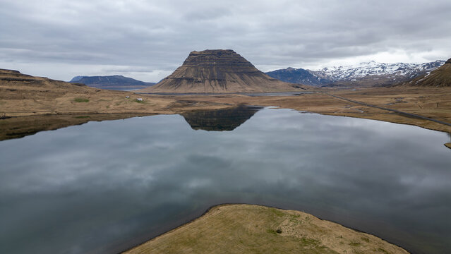 un volcan au bord d'un lac en Islande sous un ciel couvert 