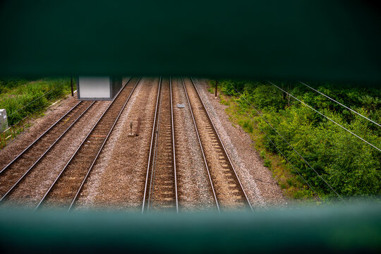 High angle view of parallel railway tracks framed through a narrow gap