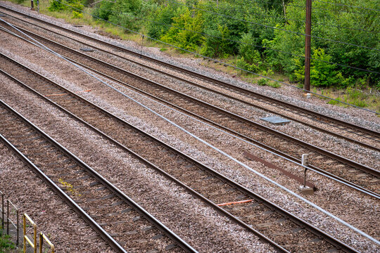 High angle diagonal view of parallel steel railway tracks and gravel ballast