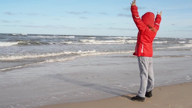 Little girl walks along shore of Baltic Sea