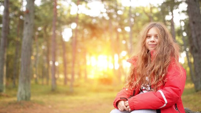 smiling little girl in red jacket in autumn park