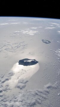 Vertical flying over Mauritius and Reunion Island with curved Earth horizon above the Indian Ocean satellite view from space based on Nasa imagery
