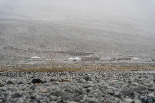 Remote Kazakh Nomadic Settlement with Yurts and Log Cabins in Snowstorm, Mongolian Altai Mountains