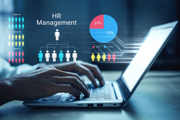Obraz premium A focused professional engages with a laptop displaying HR management graphics, showcasing data analysis, team performance, and human resource strategies in a modern workspace. Ledger