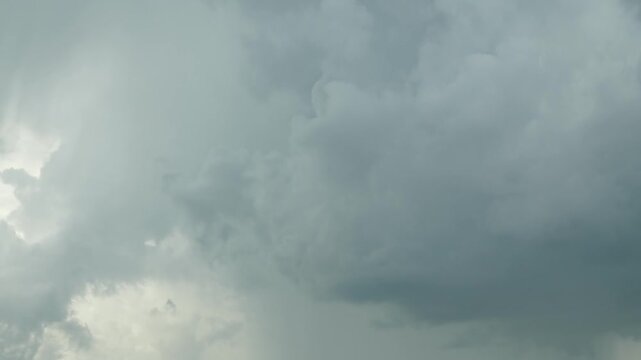 Gray dark layered rain clouds are moving rapidly across the sky, gathering into formidable thunderclouds. Timelapse. The skies before rain and thunderstorms. Horizontal video