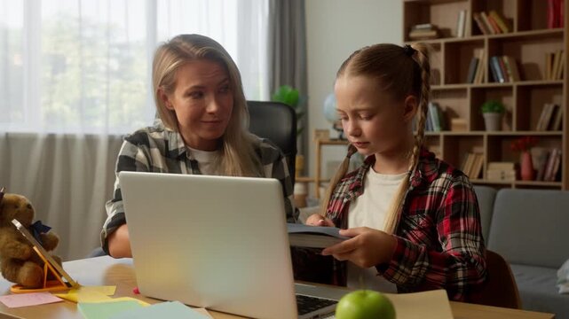 Playful little girl bad behavior grimacing at laptop refusing study sad mother Caucasian student daughter schoolgirl child at home disappointed woman mom female parent give book learner kid throw out