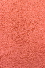 Fototapeta premium Salmon pink rough plaster wall. Architectural seamless pattern of a concrete wall. Textured background.