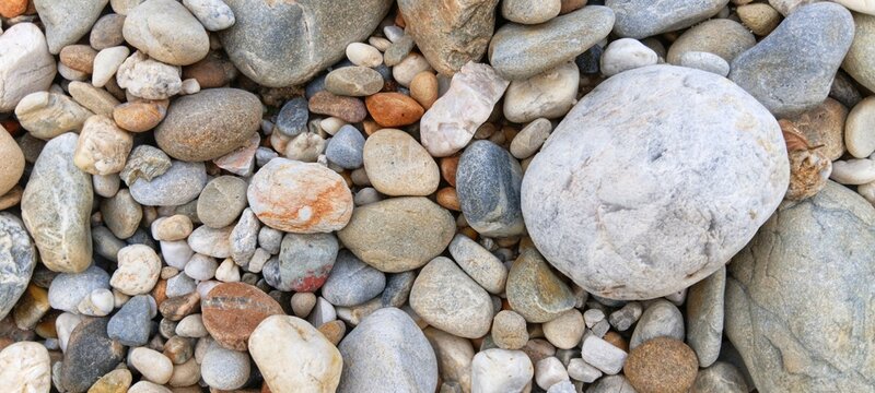 Heavy volcanic river rocks contrasting with tiny smooth gravel, creating a raw industrial texture suitable for architectural layout designs