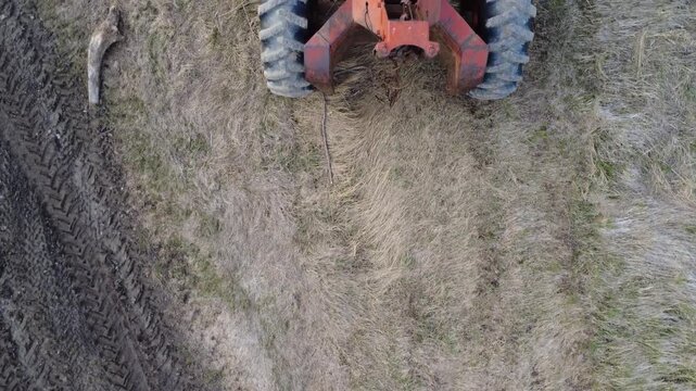 Detailed aerial pass over a vintage forestry tractor parked on a rural track, revealing textures, machinery design, and rustic surroundings.