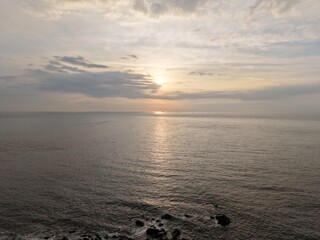 Obraz premium Aerial seascape with a sunset reflecting on the calm ocean.