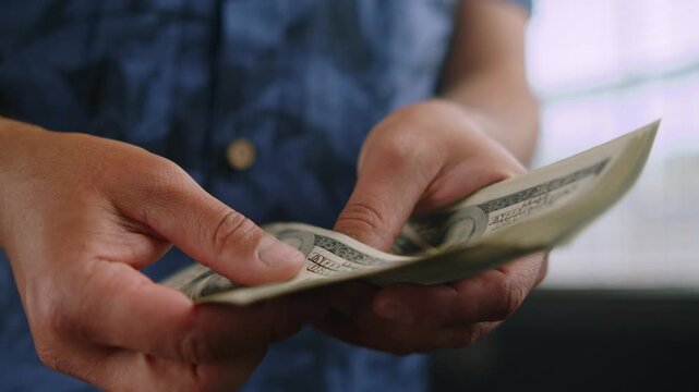 Hands carefully count crisp dollar bills in a bright, inviting room. The atmosphere buzzes with excitement as possibilities unfold, promising new ventures ahead