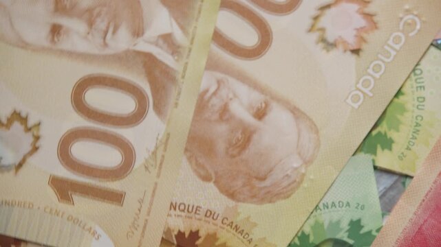 Stacks of Canadian banknotes come alive with bright colors and intricate patterns. Each bill tells a story, featuring national pride and iconic symbols of Canada