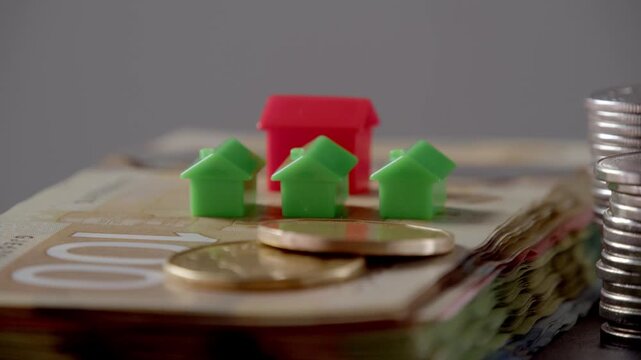 Players engage in a thrilling game of real estate, surrounded by vibrant houses and gleaming coins, all set against a backdrop of colorful banknotes