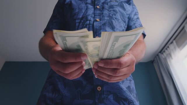 Hands skillfully arrange multiple bills in a cheerful setting, sunlight streaming through the window, highlighting the joyful act of managing money