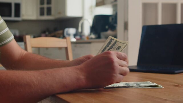 Hands diligently sort and count cash on a warm wooden table in a bright kitchen, with afternoon light creating a welcoming atmosphere