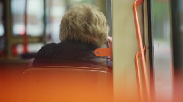 Soft focus interior view of a passenger sitting inside a public transportation vehicle
