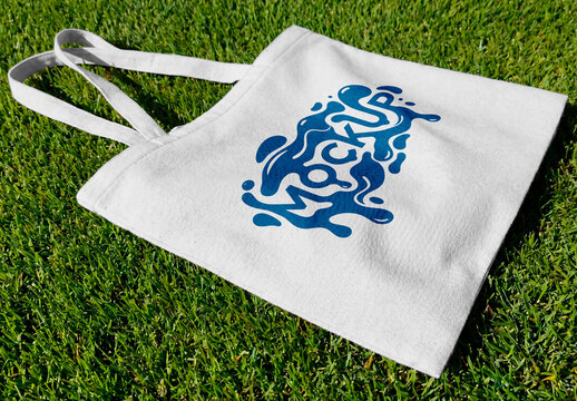 Canvas tote bag lying on green grass outdoor minimal eco lifestyle