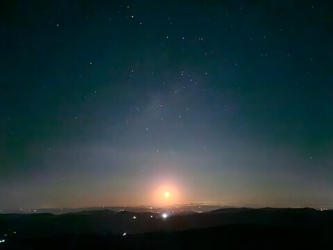 Bright moon rising above the horizon under a starry sky near Serra Negra, S&atilde;o Paulo, Brazil.