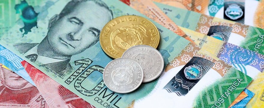 Costa Rican colon money bills and coins on table. Costa Rica cash of CRC currency close up