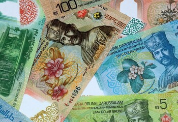 Brunei dollar money banknotes bunch on table. Brunei bills of BND currency close up © Larysa