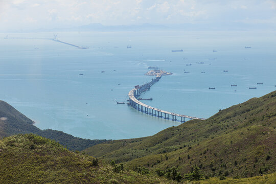 View of Hong Kong coastal infrastructure with shipping routes, cargo vessels and bridge construction. Global trade, logistics and maritime industry concept.