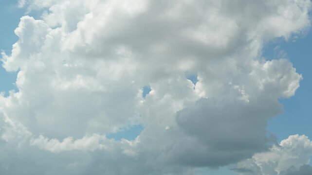 Timelapse. White cumulus clouds move rapidly in the blue sky, changing their shape and size. Clouds in the sky. Horizontal video. Heavenly landscape
