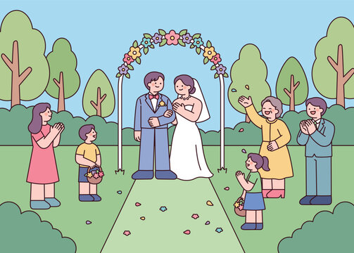 Outdoor wedding ceremony with bride, groom, family, and flower girls in a garden setting.