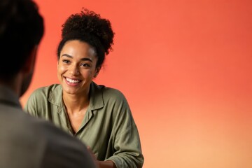 Obraz premium Smiling young woman in casual conversation against warm orange studio background