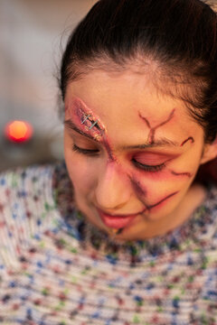 Portrait of a redhead with realistic stapled wounds and bruising on her face
