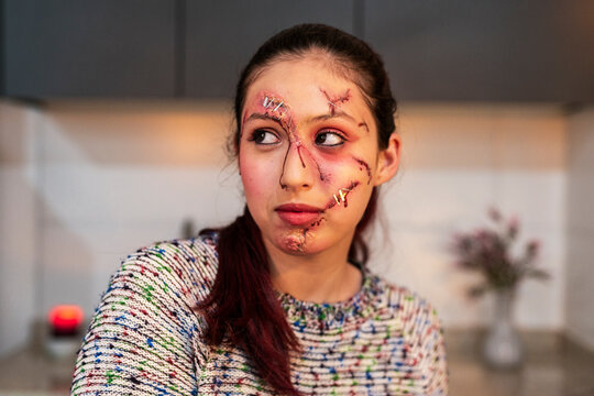 Flash lit portrait of a redhead horror character with bloody facial wounds