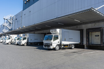 物流倉庫の積み下ろし場に多数のトラックが待機 © michitadakazu