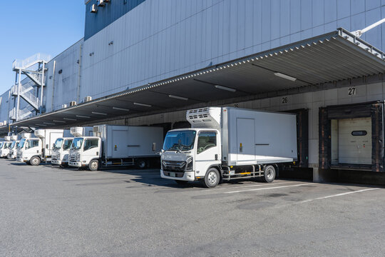 物流倉庫の積み下ろし場に多数のトラックが待機