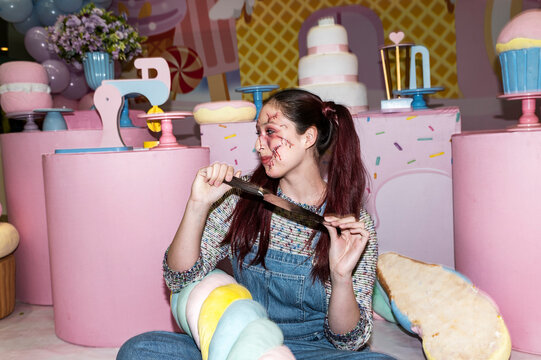 Sinister doll character crouching with a knife in a pastel candy themed set