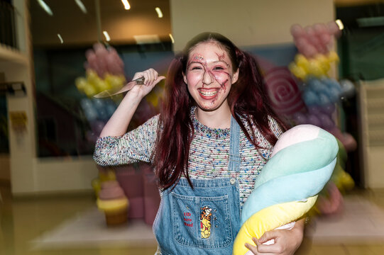 Menacing doll character with a plush toy and knife in a candy themed wonderland