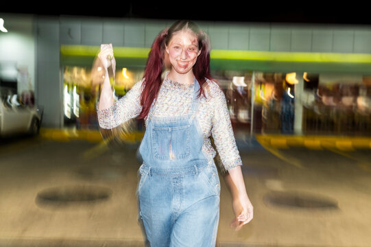 Costumed killer doll character stalking with a knife at a night gas station