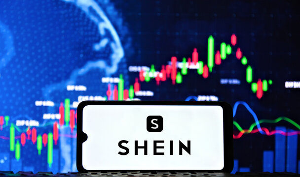 Shein fashion company logo displayed on a smartphone screen with financial stock market candlestick chart in the background
