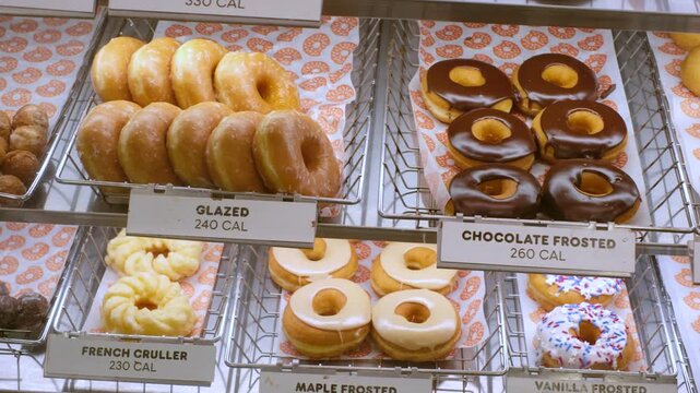 Fresh donuts in display case with calorie count labels