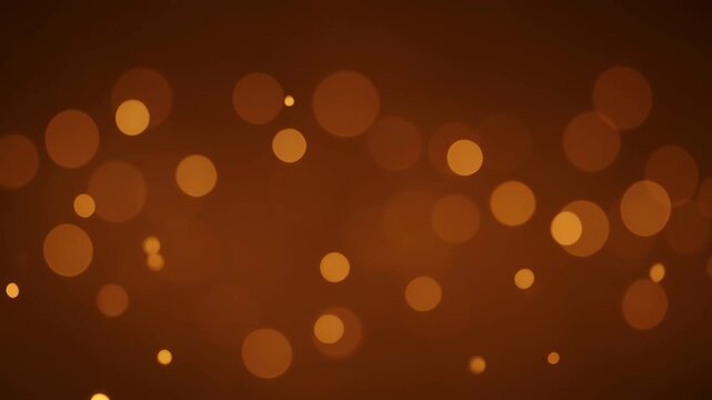 Abstract bokeh light glowing warm orange background with soft blurred circles and festive shimmer pattern