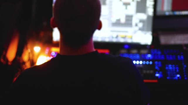 Lighting engineer operator working on mixing console workplace during live event concert on stage show broadcast, light mixer controller panel, sound technician workplace with professional equipment